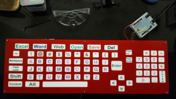 complete keyboard with wires and buttons underneath the acrylic buttons. The acrylic buttons are labeled with letters and numbers to indicate their function.