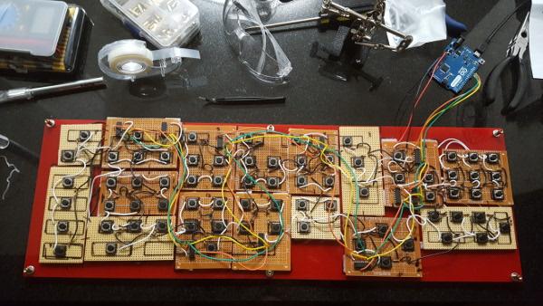 all of the circuit boards together on an acrylic sheet, with buttons facing up and lots of wires connecting everything together.