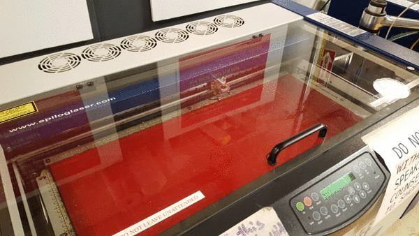 laser cutter cutting through sheets of acrylic