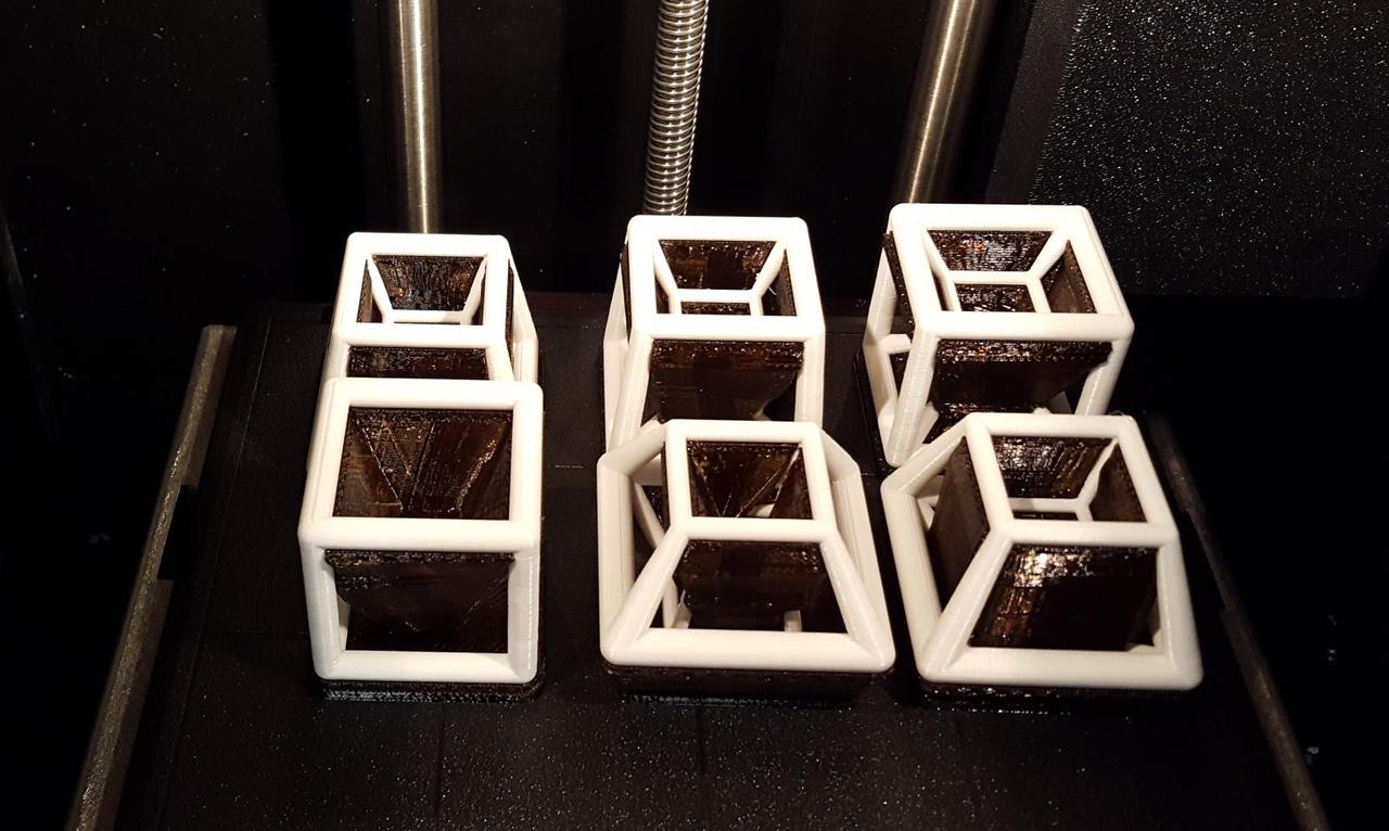 one cube and five hypercubes sitting on the Stratesys print bed.