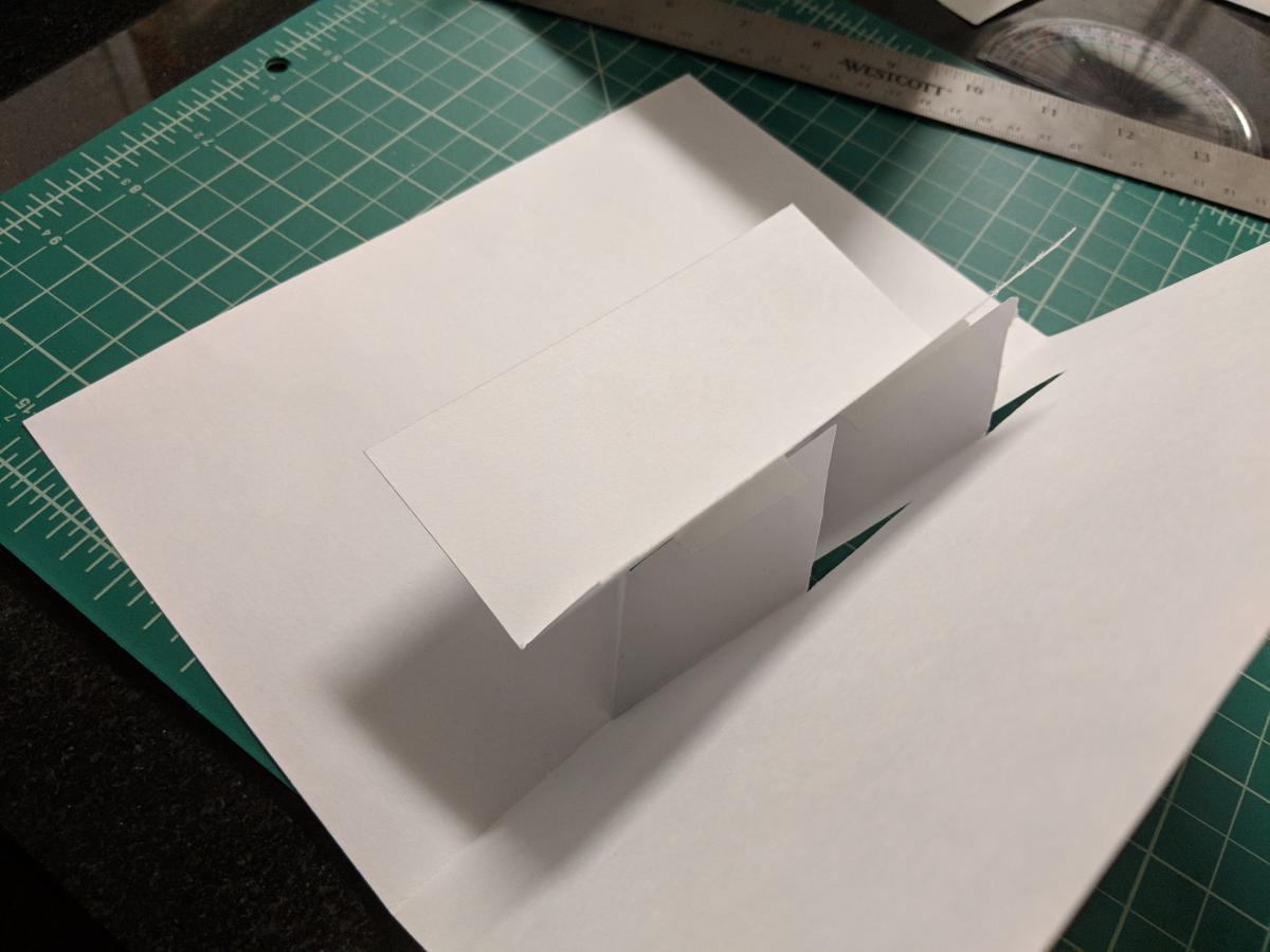 folded paper card with raised platform surface coming out of the center.