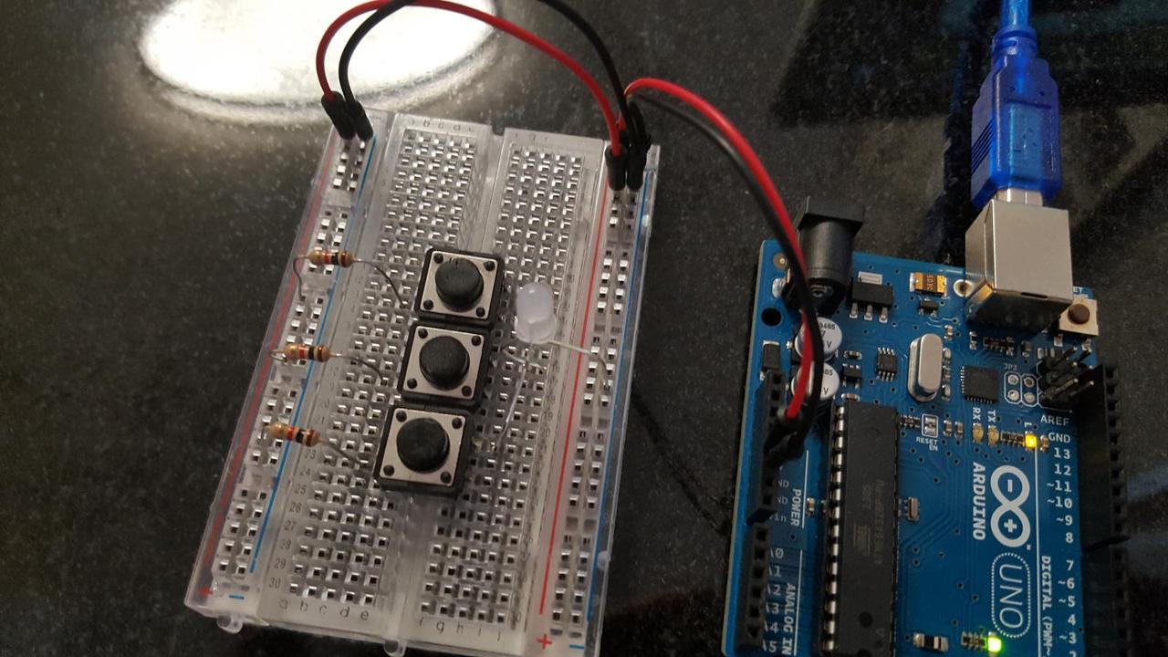 Arduino, breadboard with 3 buttons and 3 identical resistors, all connected to a 3 color LED.