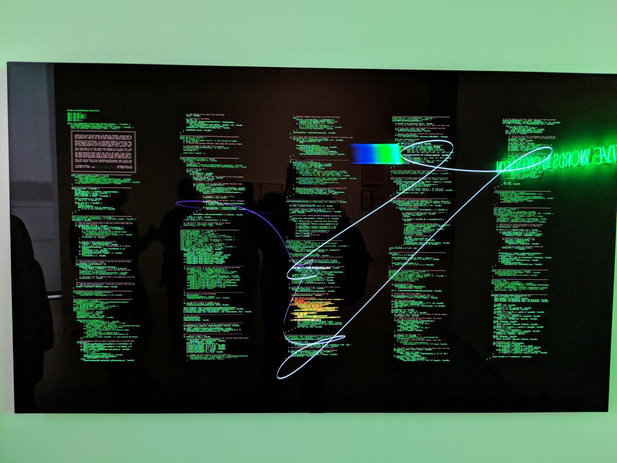 Large computer monitor displaying computer code with individual lines lit up as the computer is executing each line.