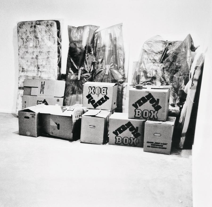 stacked boxes and miscellaneous items wrapped in fabric.