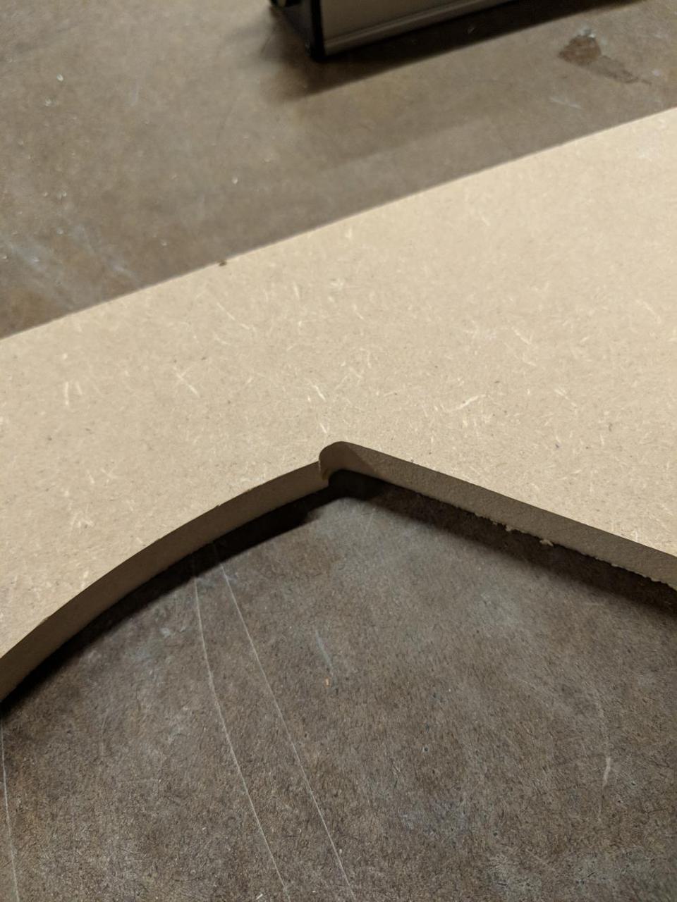 edge of piece of wood with sloppy corner, with two cut lines partially overlapped.
