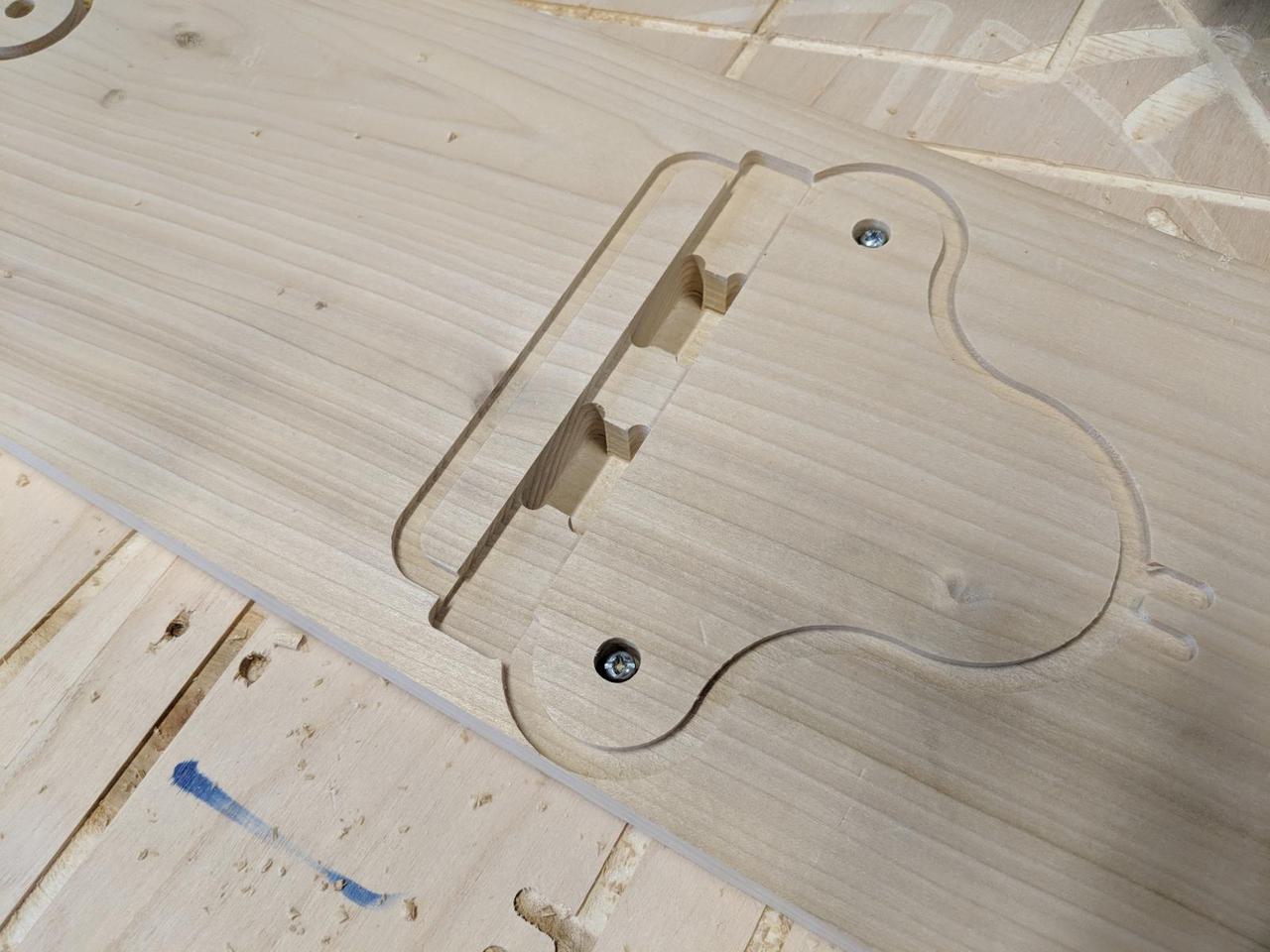 wooden piece screwed down onto CNC bed