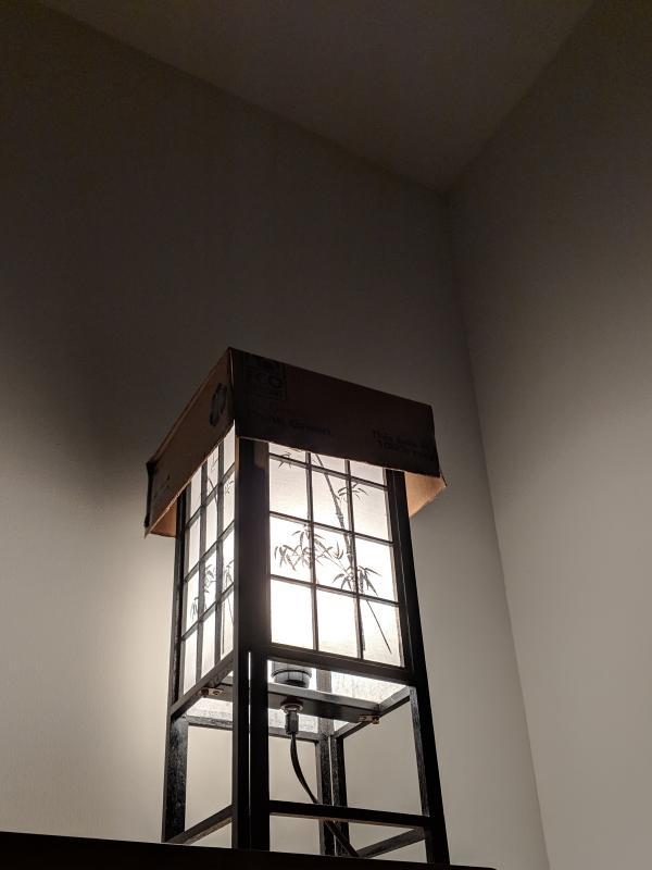 Table desk with cardboard cover on top, blocking light from hitting the wall