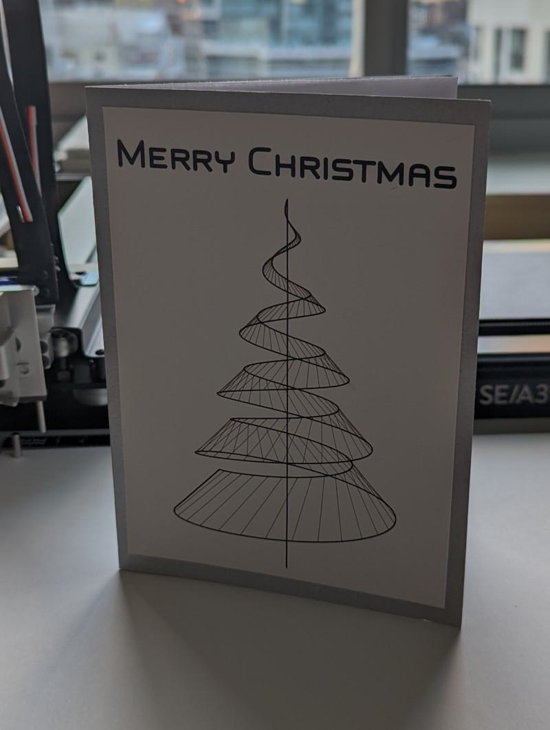 holiday card with a wire frame christmas tree and the words "merry christmas" across the top
