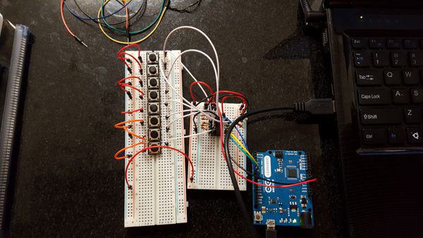 Arduino connected to a breadboard with lots of wires reading from one shift register. The shift registers are recording the states of eight buttons.