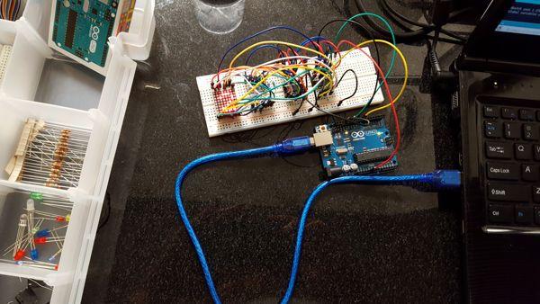 Arduino connected to a breadboard with lots of wires controlling two shift registers. The shift registers are connected to a dot matrix display, currently displaying the number 2.