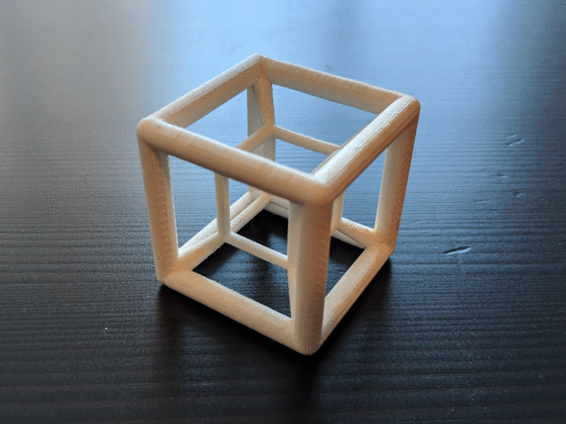animation showing each of the 5 3D printed hypercubes, one after another, sitting on a wooden table.