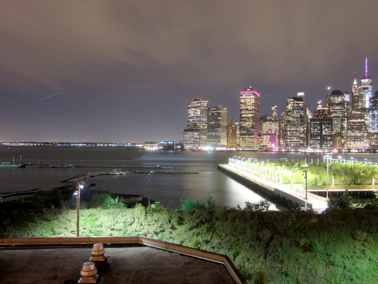 view of southern tip of manhattan at night from brooklyn