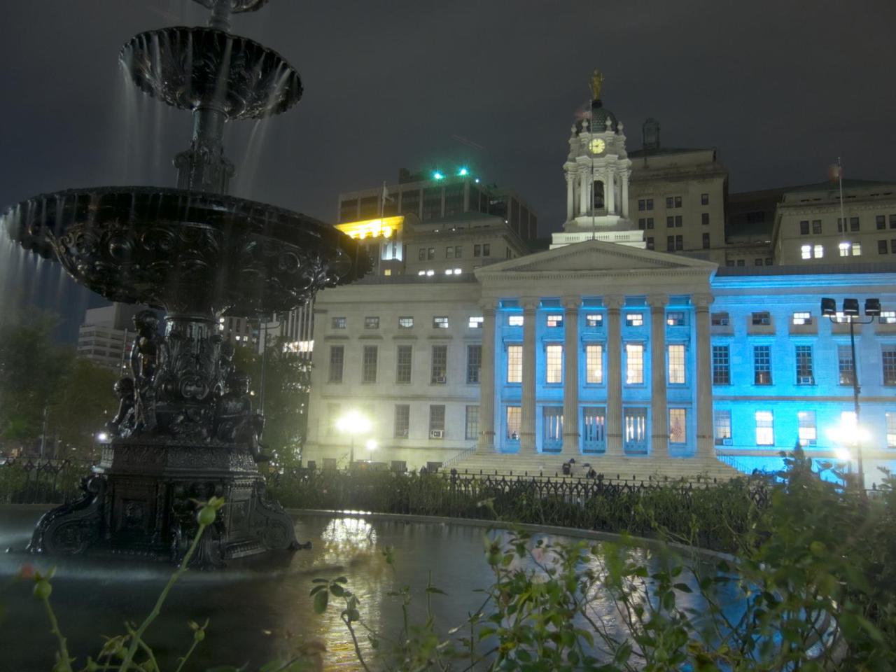 brooklyn borough hall at night, with a fountain in the foreground
