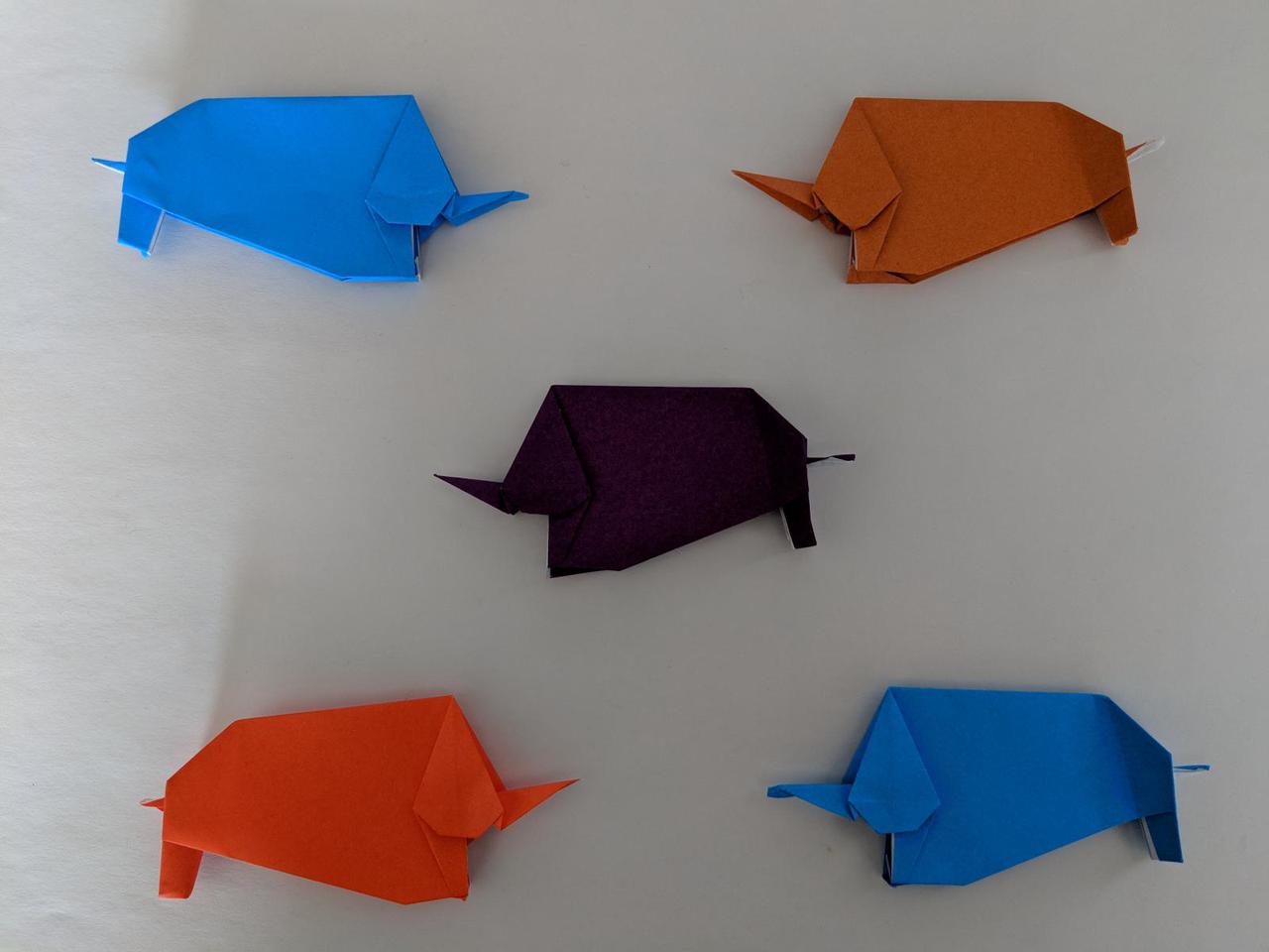 five origami elephants, each with a long trunk and fat body.