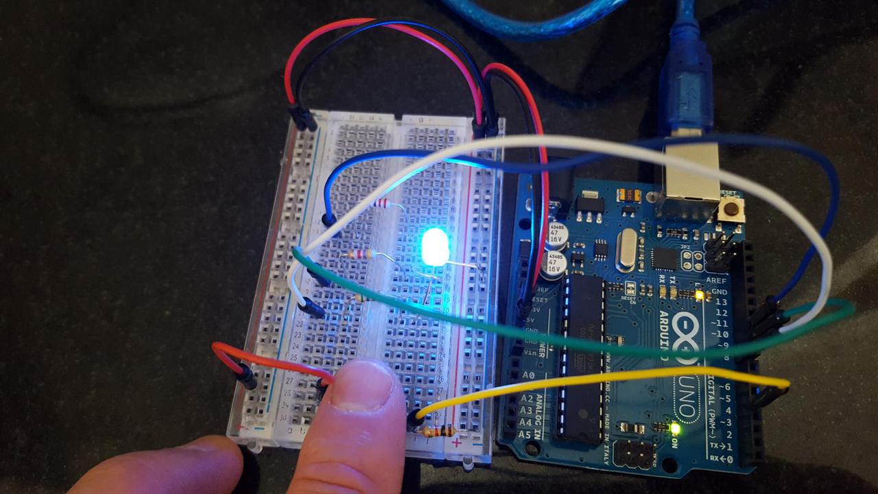 arduino connected to breadboard with single 3 color LED lit up, and three resistors connected to the LED leads, and resistors connected to pins 8, 9, and 10.