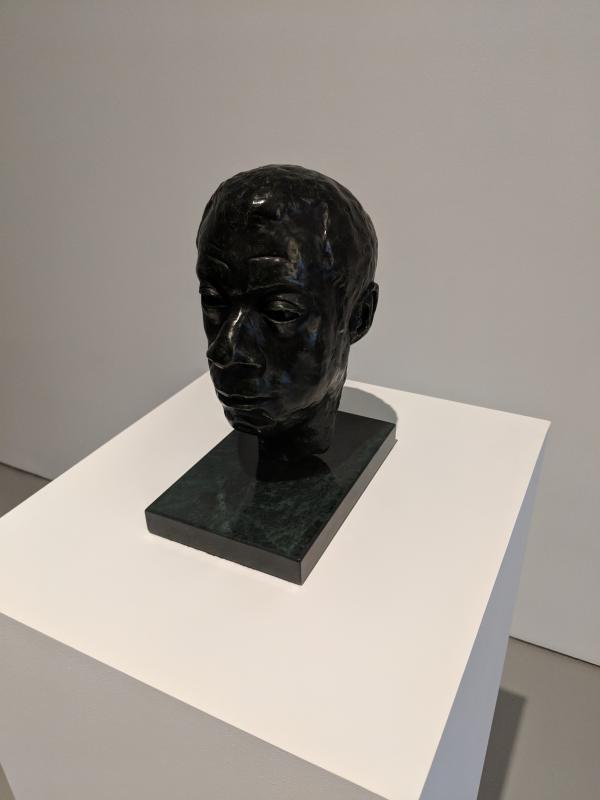 sculpture of james baldwin's head sitting on pedestal.