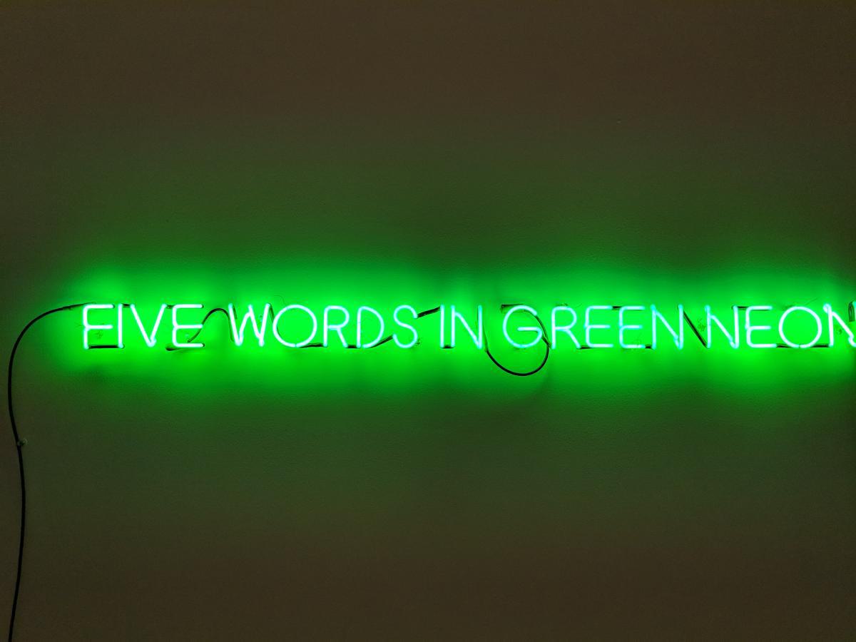 The exact words "Five Words in Green Neon" are displayed with a green neon light.