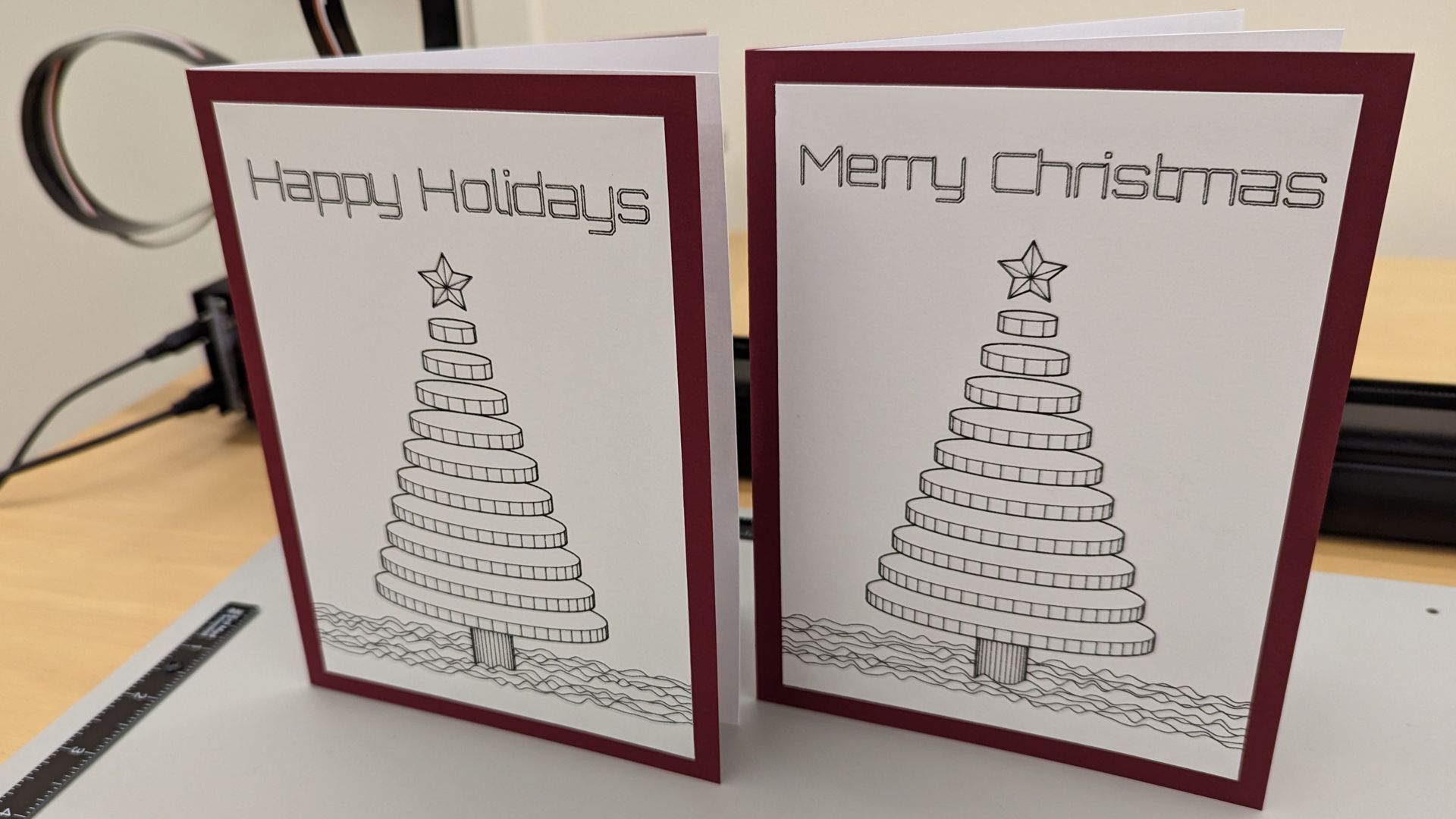 two holiday cards with a christmas tree on each and the words 