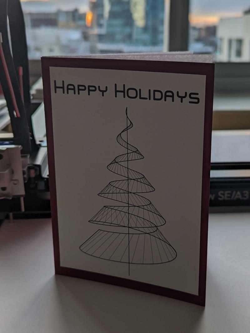 holiday card with a wire frame christmas tree and the words "happy holidays" across the top